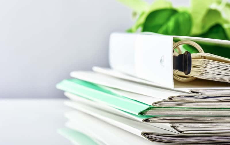 A stack of folders. topped off with a binder.