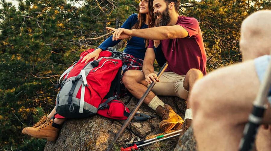 A group of hikers enjoying a break on a rock.