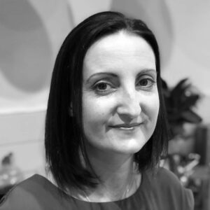 A black and white photo of a woman smiling, captured by TMA, the Tourism Marketing Agency.