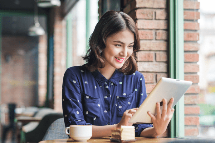 A woman using a tablet in a cafe.