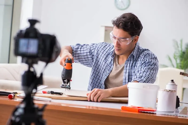 A man cuts wood with a jigsaw.