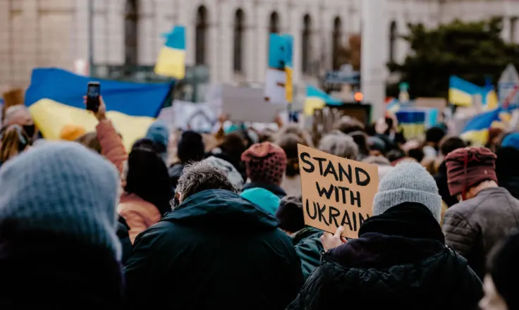 crowd holding flags and signs in support of ukraine