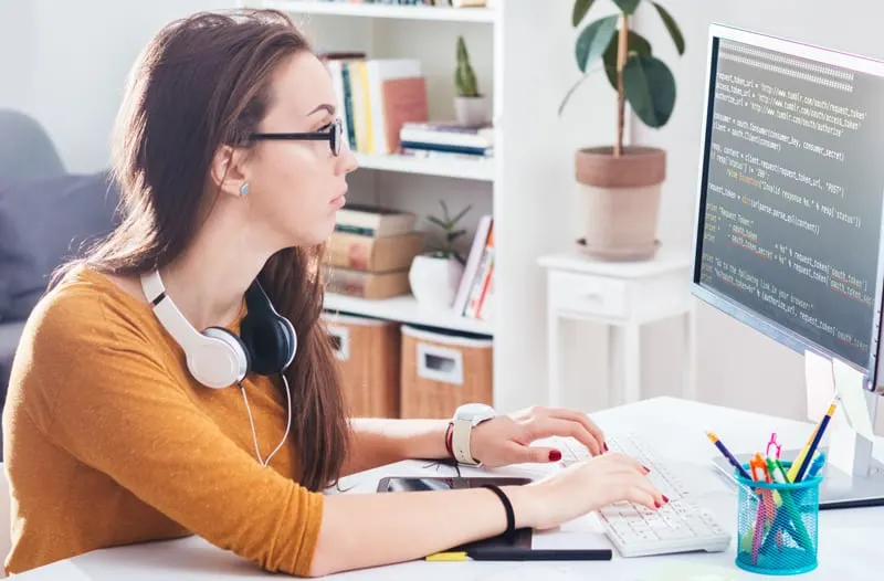 woman in orange shirt who is coding header tags 