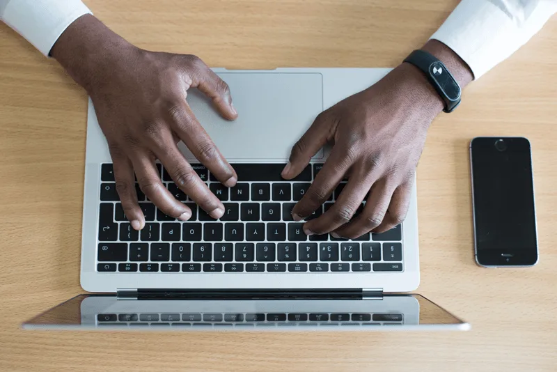 birds eye view of a man's hands typing on a laptop computer