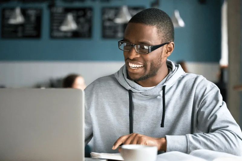 A man using a laptop computer in a cafe.