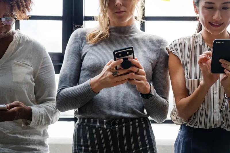 three women using mobile phones