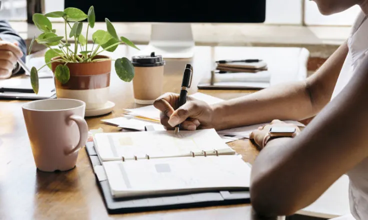 person using a planner at a desk